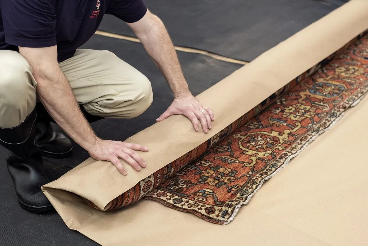 Apollo mover carefully rolling and wrapping an area rug